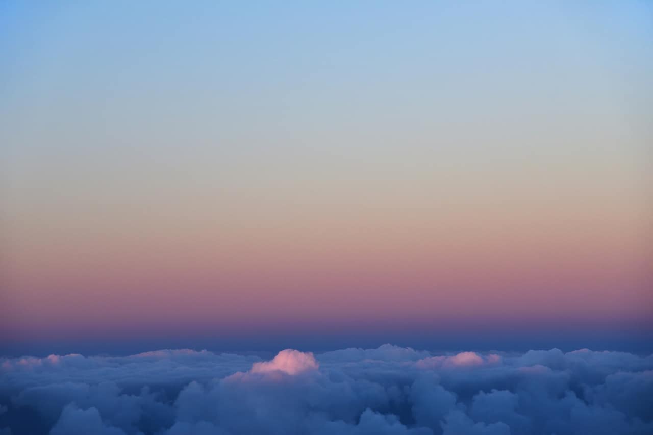 A sea of cloud at dusk, the sky shading from blue to rose along the horizon